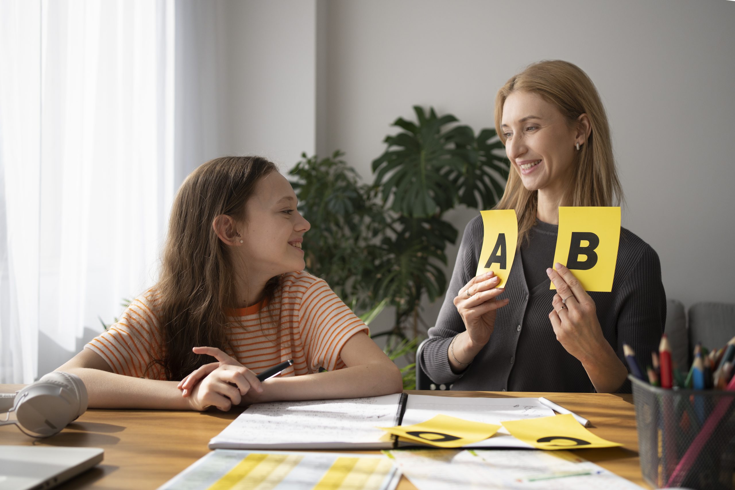 Reading tutor teaching a Science of Reading/Structured Literacy lesson to a student using letter tiles and a notebook